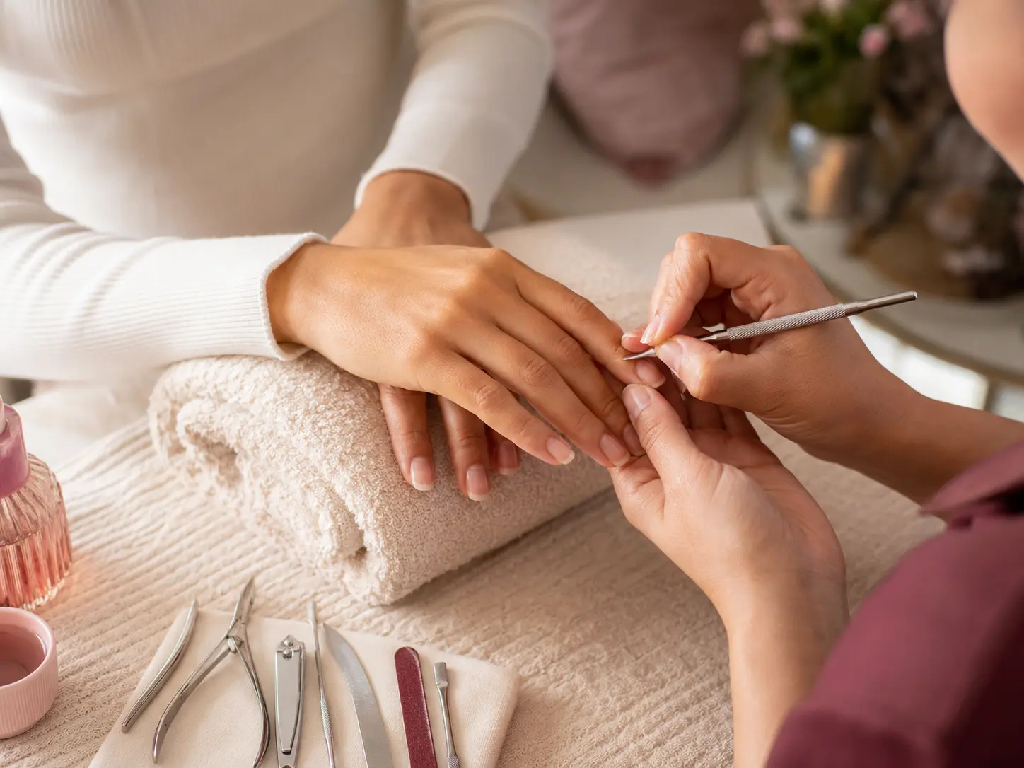 Manicurista preparando las uñas de una clienta
